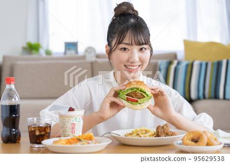作弊日 一個手裡拿著漢堡的年輕女人微笑著 95629538
