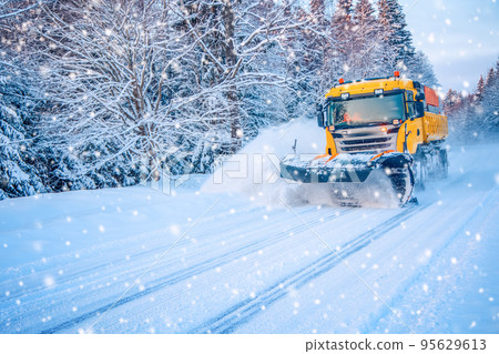 Snow plow truck cleaning road in snowstorm. Snow plow truck cleaning road in snowstorm. 95629613