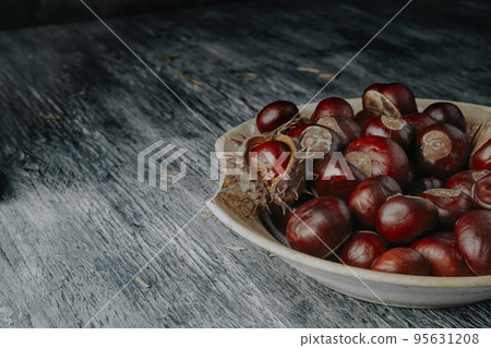 chestnuts on an old and weathered plate chestnuts on an old and weathered plate 95631208