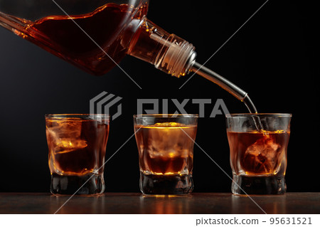 Whiskey in glasses with ice. 95631521