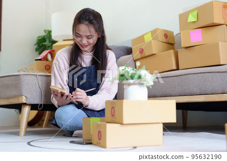 Portrait of Starting small businesses, Asian woman check online orders Selling products working with boxs freelance work at home office, sme business concepts 95632190