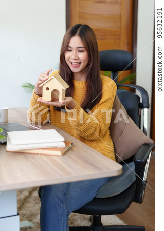 A woman showing joy after making a successful purchase of a house with a bank. 95632191