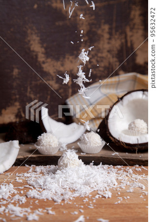 Close up of white candies and coconut with white pulp, coconut chip on wooden background.. Close up of white candies and coconut with white pulp, coconut chip on wooden background.. 95632472