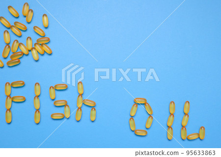 Pharmaceutical medicine capsules on blue background. Fish oil. Transparent fish oil on a blue background 95633863