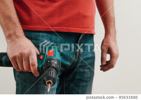 Hand holding cordless drill. Handyman with a tool screwdriwer drill. Hand holding cordless drill. Handyman with a tool screwdriwer drill. 95633880