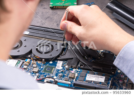 Hands fixing motherboard of pc or laptop notebook close up in service. Laptop repair service. 95633960