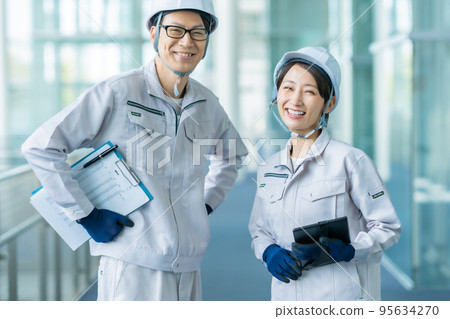 Engineer in work clothes working in a modern factory 95634270