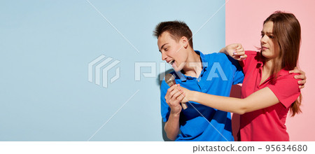 Portrait of young people, man and woman posing with microphone, singing battle isolated over blue-pink background. Flyer Portrait of young people, man and woman posing with microphone, singing battle isolated over blue-pink background. Flyer 95634680