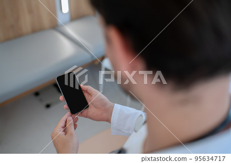 Healthcare worker using the smartphone in his office Healthcare worker using the smartphone in his office 95634717