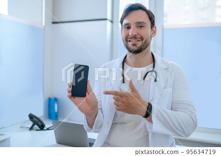 Joyous physician with the smartphone in the hand Joyous physician with the smartphone in the hand 95634719