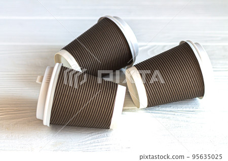 Disposable paper coffee cup on white table 95635025