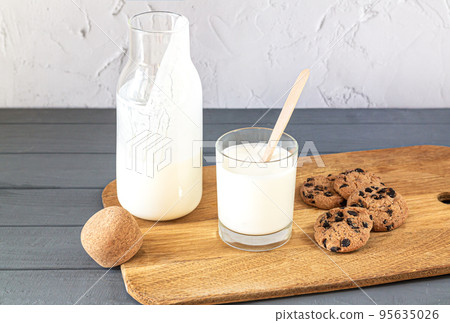 Bottle of kefir, buttermilk or yogurt, glass on kitchen table 95635026