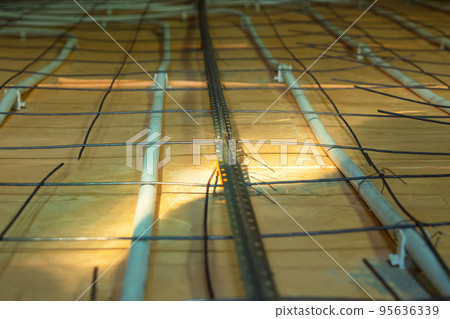 Floor heating system in a private home. In close-up. Mounting the floor heating. Preparing to pour concrete floor. Selective focus. Floor heating system in a private home. In close-up. Mounting the floor heating. Preparing to pour concrete floor. Selective focus. 95636339