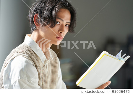 Young man reading by the window 95636475