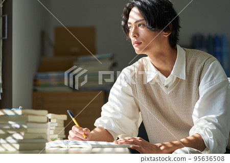 Young man studying by the window 95636508