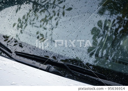 Car wipers and windshield with raindrops on it, closeup Car wipers and windshield with raindrops on it, closeup 95636914