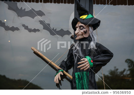 Halloween witch doll decoration with broom and many flying bats. Halloween witch doll decoration with broom and many flying bats. 95636950