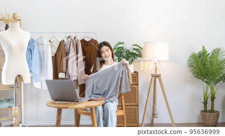 Beautiful woman with social media influences performing live or recording shows selling cheap fashion clothes in her studio, Recording vlog video live streaming, Online fashion clothing business. 95636999