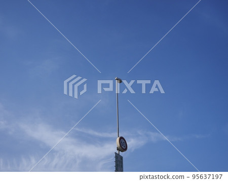 A view of the highway streetlights and the expansive blue sky A view of the highway streetlights and the expansive blue sky 95637197