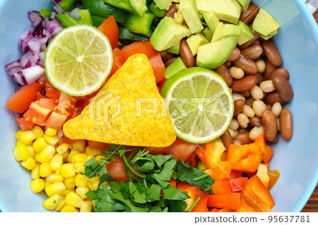 Salad texas caviar close up. Vegetable dish with corn, beans, pepper, pepper, tomatoes, beans. Served with corn chips nachos Salad texas caviar close up. Vegetable dish with corn, beans, pepper, pepper, tomatoes, beans. Served with corn chips nachos 95637781