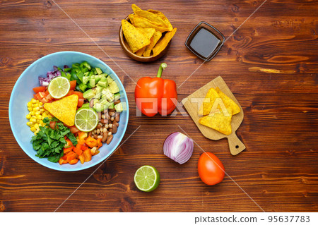 Homemade organic cowboy caviar with corn beans, tomatoes, peppers, lime, avocado, onion Wooden background Homemade organic cowboy caviar with corn beans, tomatoes, peppers, lime, avocado, onion Wooden background 95637783