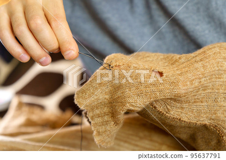 Mending clothes. Concept of mending and repairing clothes. Creative sustainable fashion and recycling. Mending clothes. Concept of mending and repairing clothes. Creative sustainable fashion and recycling. 95637791