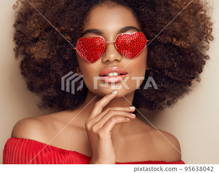 Beautiful portrait of an African girl in sunglasses in the shape of hearts 95638042