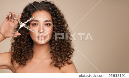 Beautiful young woman with a scissors 95638191