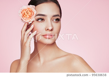 Beautiful young woman with a rose flower Beautiful young woman with a rose flower 95638638