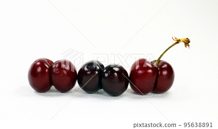 Unusually shaped cherries, fused by two berries isolated on white. Ripe juicy sweet burgundy cherry close-up, macro Unusually shaped cherries, fused by two berries isolated on white. Ripe juicy sweet burgundy cherry close-up, macro 95638891