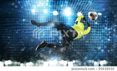 Soccer goalkeeper makes a great save and avoids a goal on a dark blue background 95639430