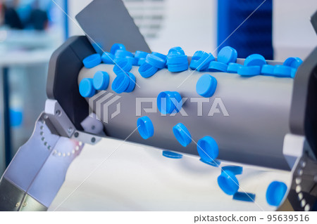 Many blue plastic bottle caps falling from conveyor belt - production line Many blue plastic bottle caps falling from conveyor belt - production line 95639516