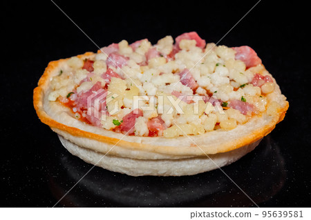 Uncooked homemade mini pizza on tray on tray in electric oven, black background 95639581