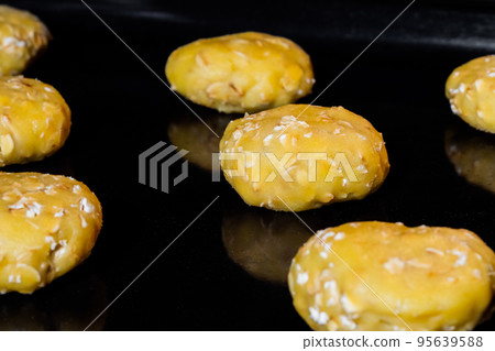 Many uncooked homemade oatmeal cookies on metal sheet in oven, black background Many uncooked homemade oatmeal cookies on metal sheet in oven, black background 95639588