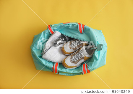 Gym bag with sports equipment on yellow background, top view Gym bag with sports equipment on yellow background, top view 95640249