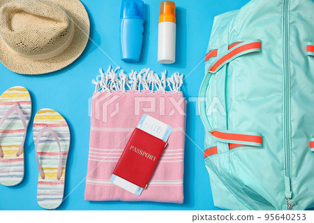 Flat lay composition with bag and travel accessories on blue background Flat lay composition with bag and travel accessories on blue background 95640253