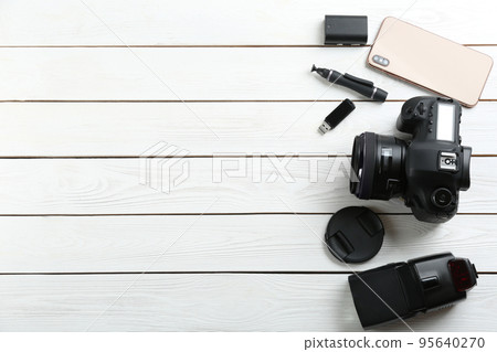 Flat lay composition with equipment for professional photographer on white wooden table. Space for text 95640270