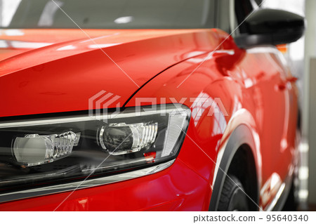 New luxury car in modern auto dealership, closeup New luxury car in modern auto dealership, closeup 95640340