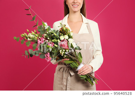 Florist with beautiful bouquet on pink background, closeup 95640528