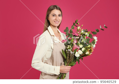 Florist with beautiful bouquet on pink background 95640529
