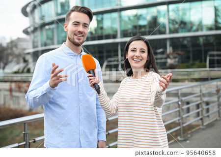 Young journalist interviewing man on city street Young journalist interviewing man on city street 95640658