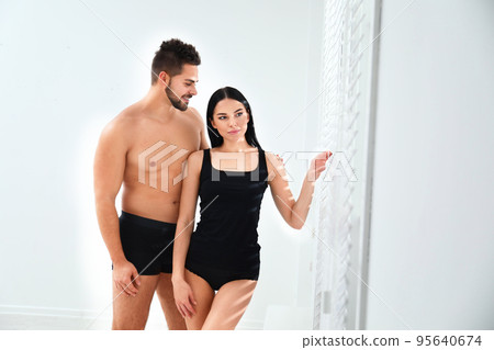 Young couple in black underwear near window indoors Young couple in black underwear near window indoors 95640674