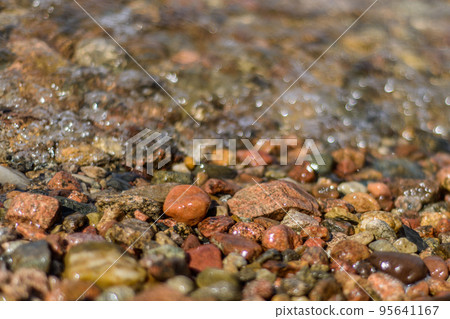 Brightly colored rocks washed by waves freshwater lakes with crystal clear water Brightly colored rocks washed by waves freshwater lakes with crystal clear water 95641167