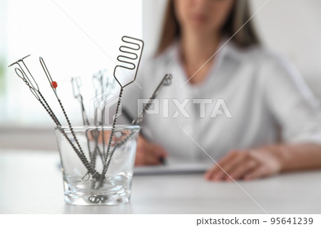 Set of different logopedic probes in holder on light table, space for text. Speech therapist's tools Set of different logopedic probes in holder on light table, space for text. Speech therapist's tools 95641239