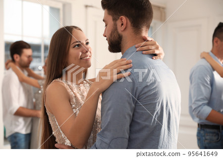 Lovely young couple dancing together at party 95641649