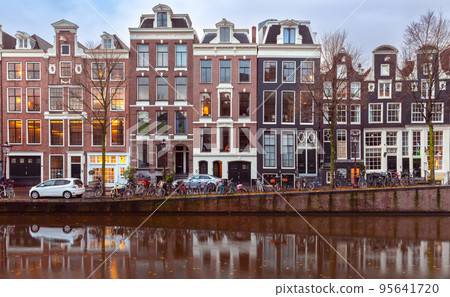 Beautiful old houses on the city waterfront of Amsterdam at sunset. 95641720