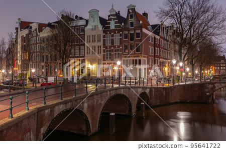 Beautiful old houses on the city waterfront of Amsterdam at sunset. 95641722