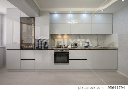 Interior of modern trendy white kitchen, front view Interior of modern trendy white kitchen, front view 95641794