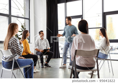 Psychotherapist working with patients in group therapy session indoors 95641822