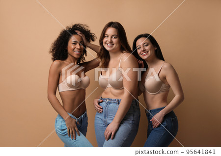 Group of women with different body types in jeans and underwear on beige background 95641841